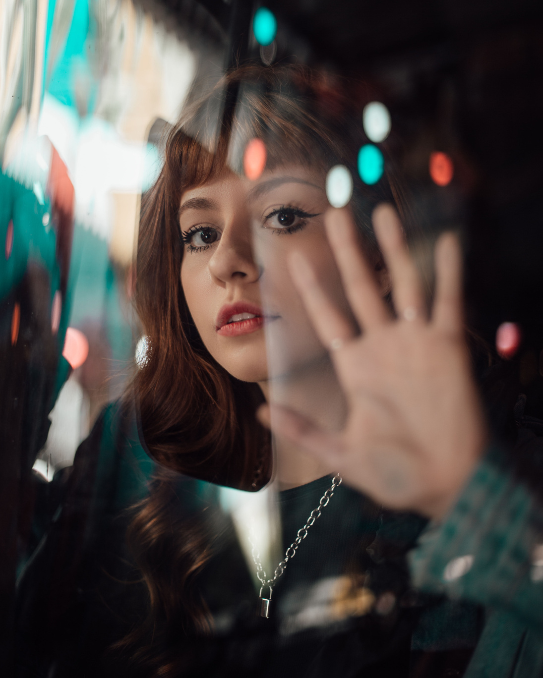 Beautiful Young Woman Touching the Glass Window